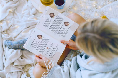 Dospievajúce dievča si číta praktickú príručku o prvej menštruácii